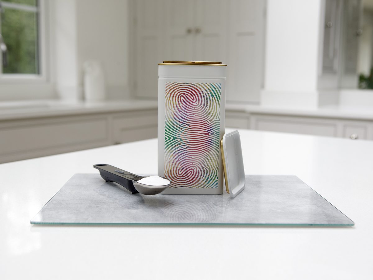 A tin beside the digital weighing scoop on the bench