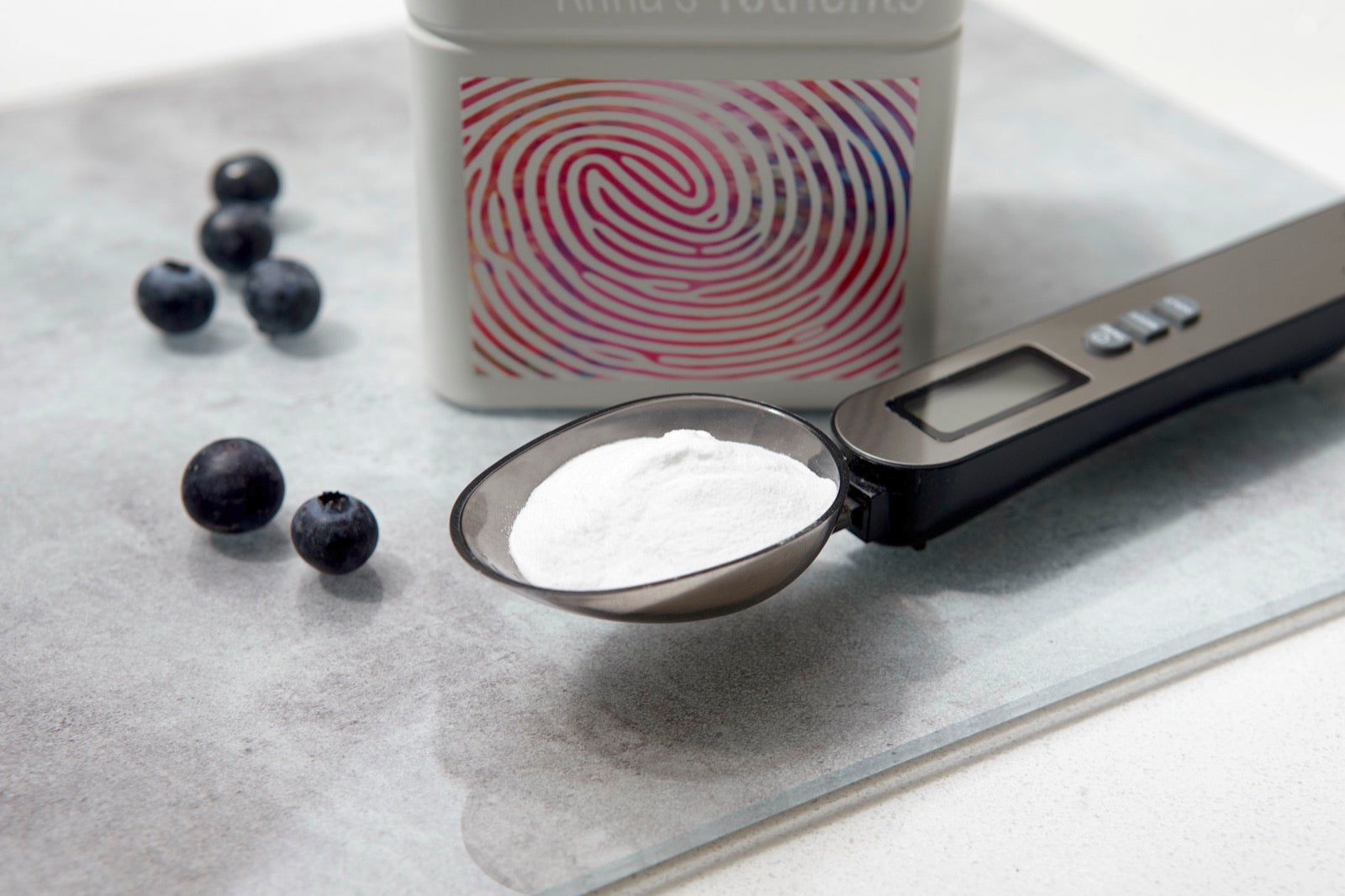 A loaded precision scoop beside a Yutrients tin